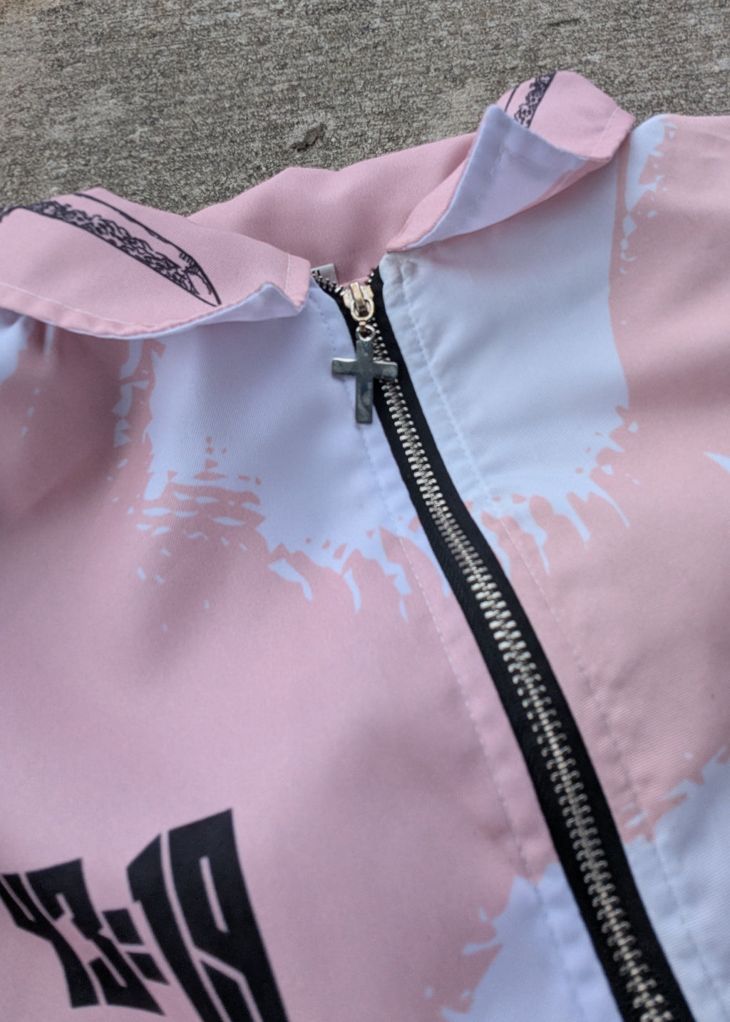 Pink jacket with a zipper on a gray pavement background