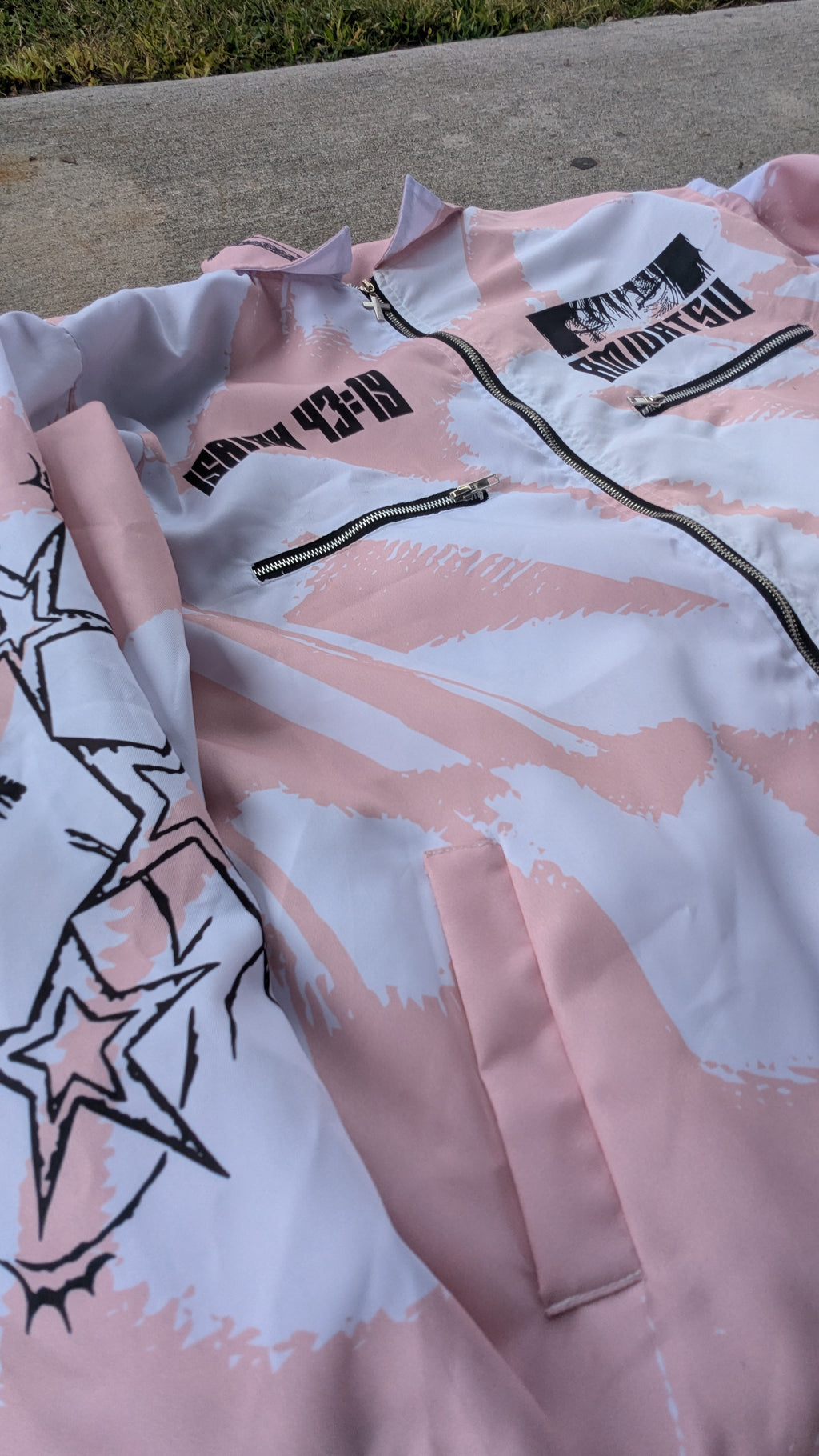 Pink jacket with black graphics on a concrete surface