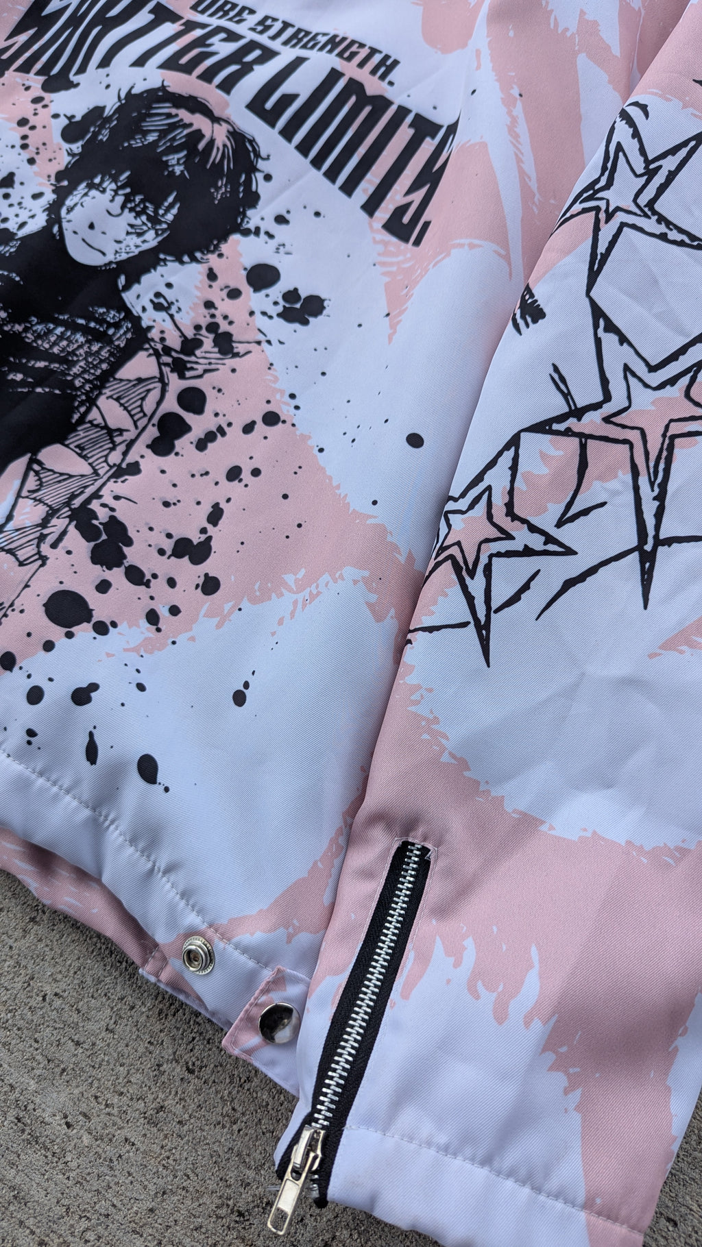 Close-up of a jacket with graphic design and text on a pink background