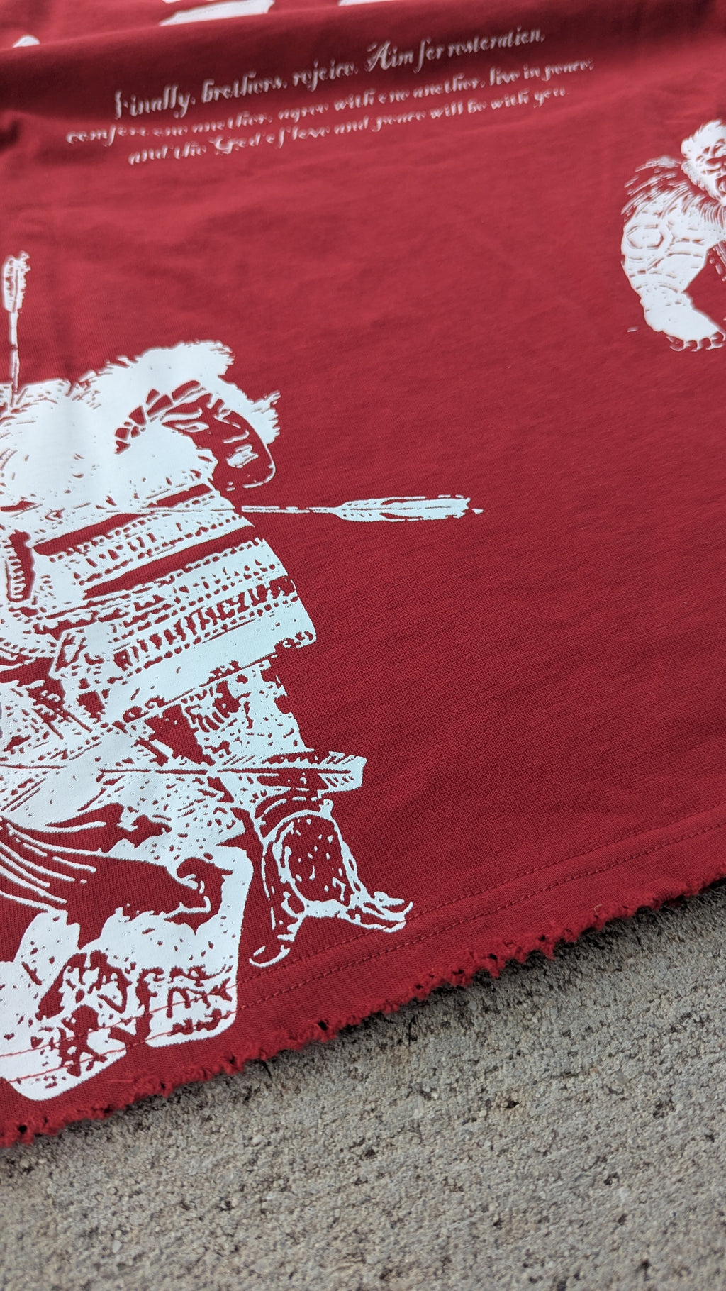Red fabric with white printed design of a warrior on horseback.