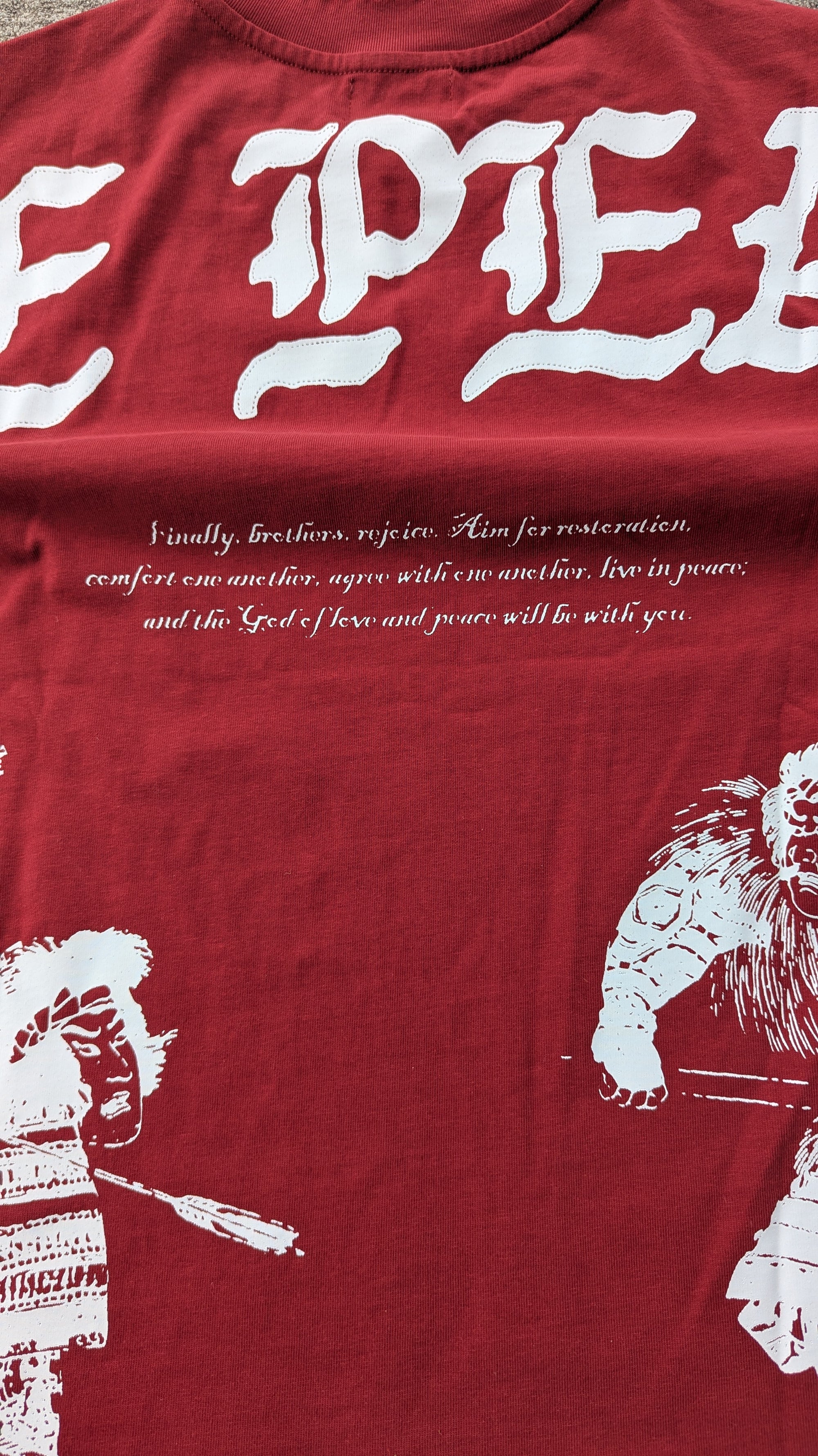 Red t-shirt with white text and graphics on a red background