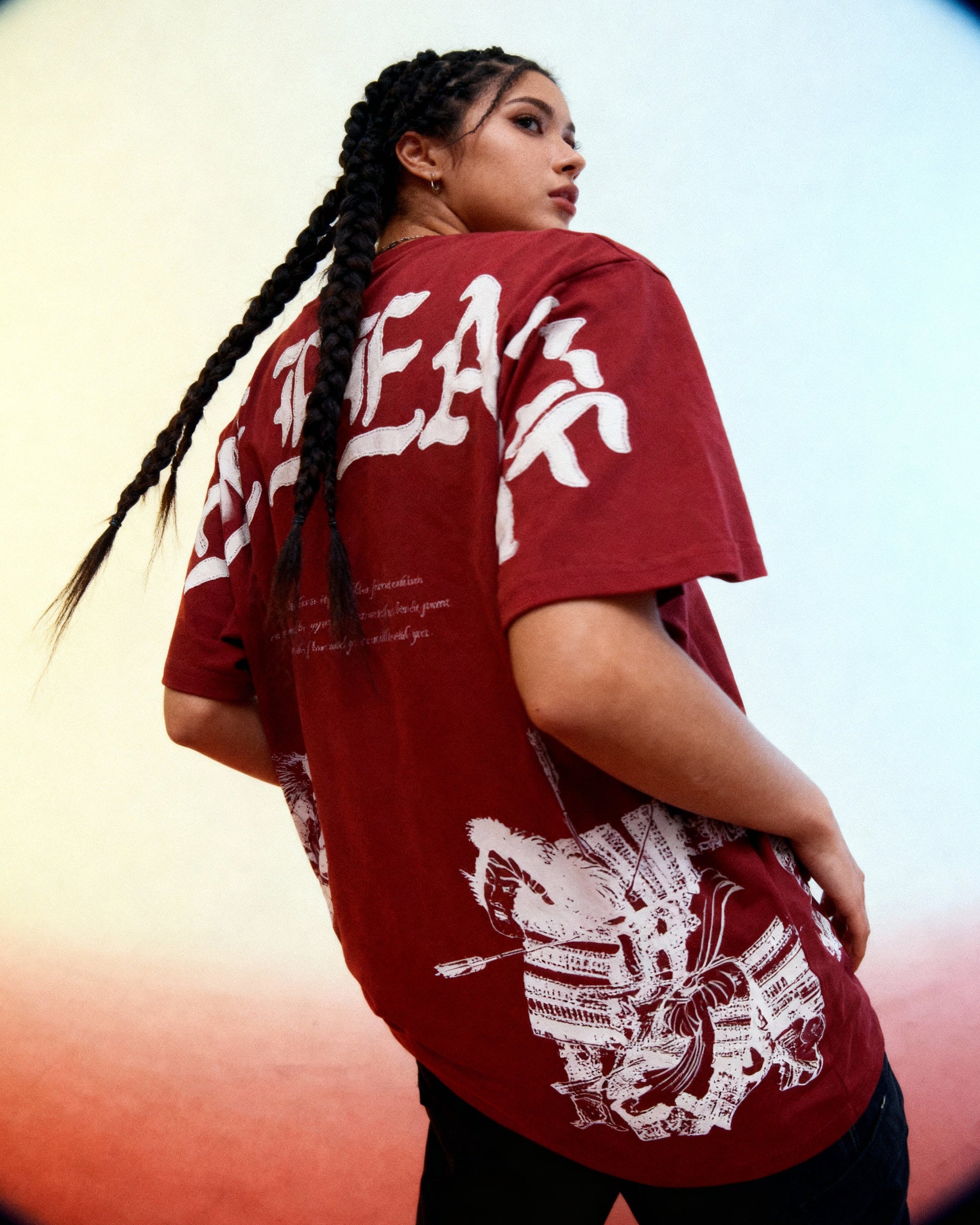 Person wearing a red t-shirt with white graphics and text against a blurred background