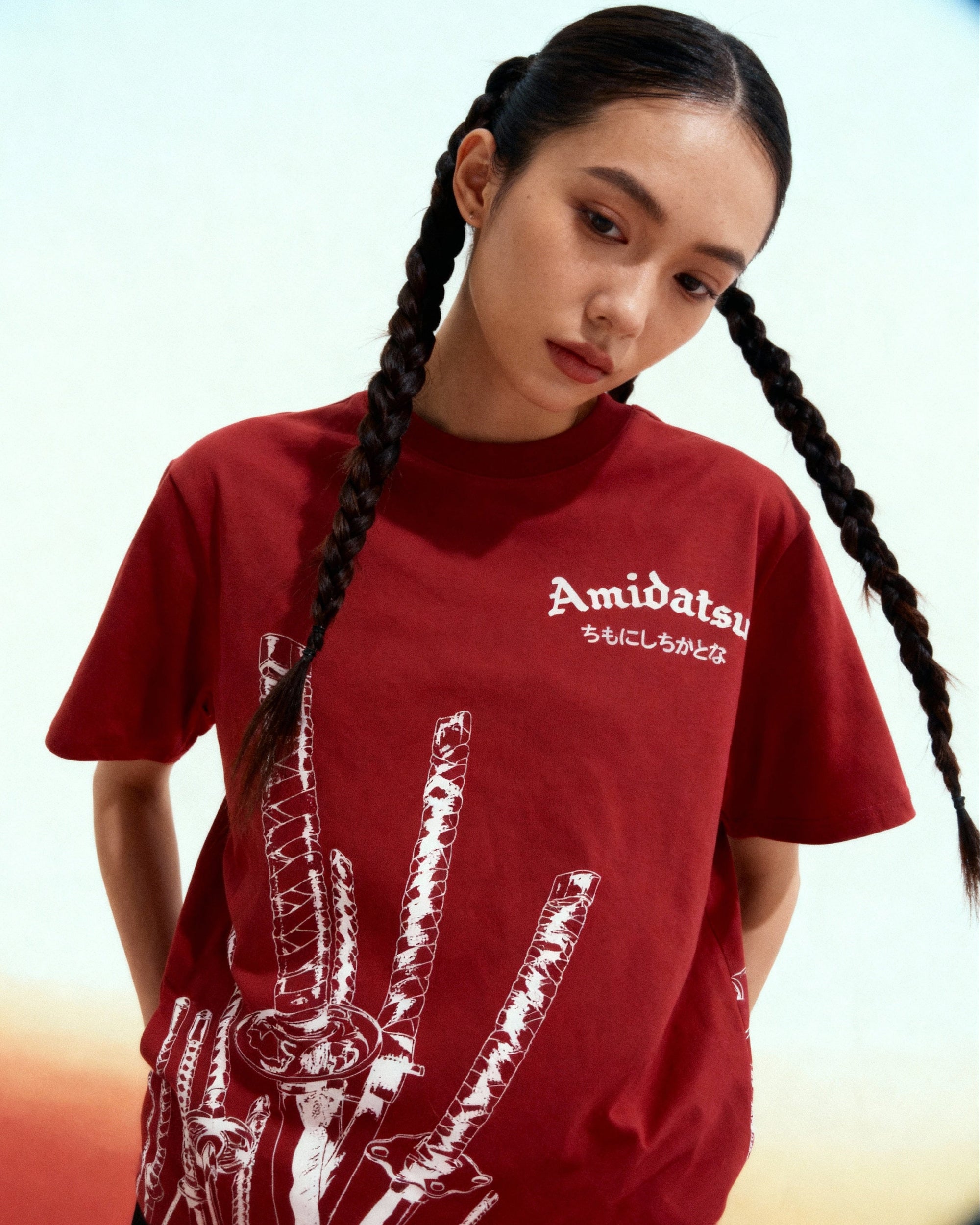 Person wearing a red t-shirt with white graphics and text, standing against a gradient background.